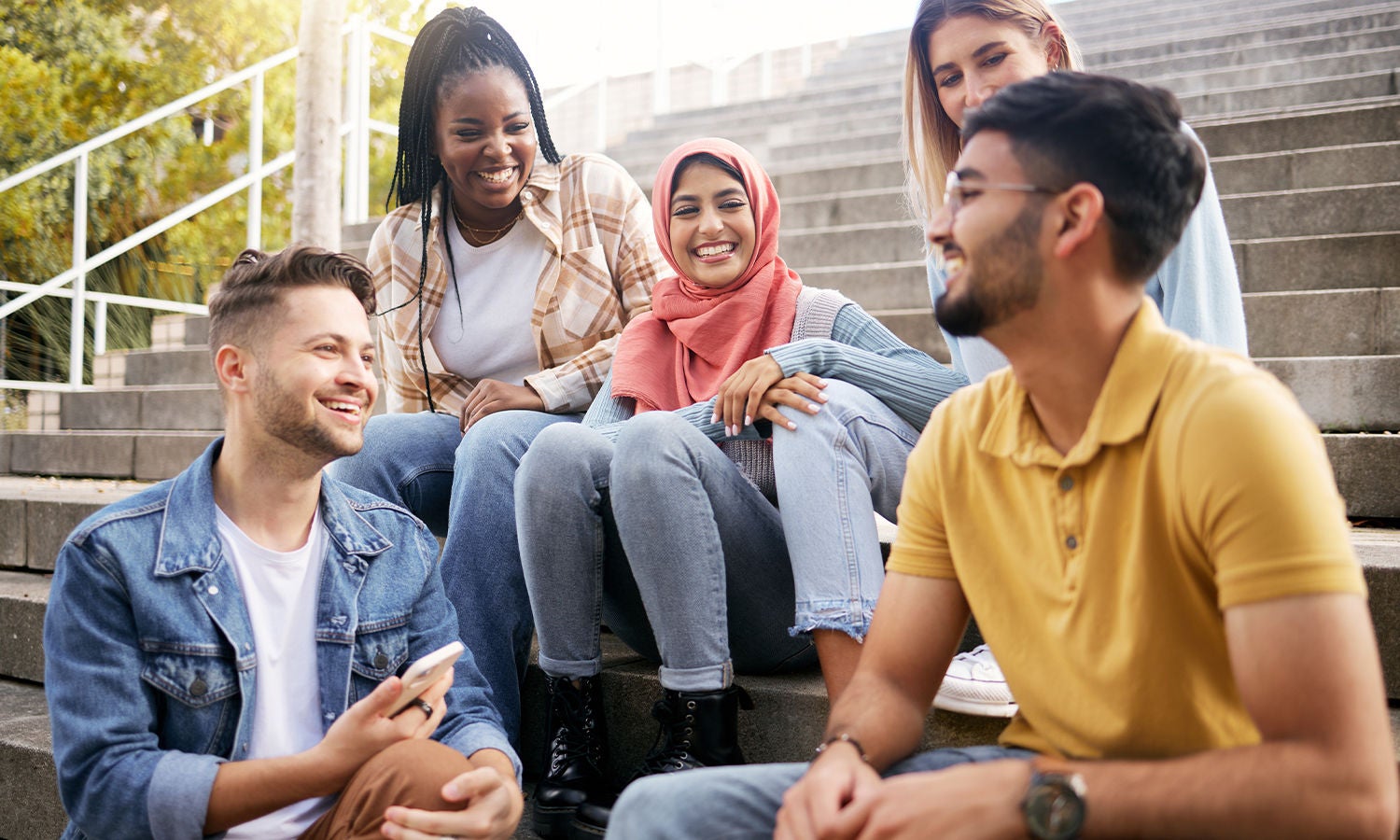 A group of college students sitting and conversing on stairs​